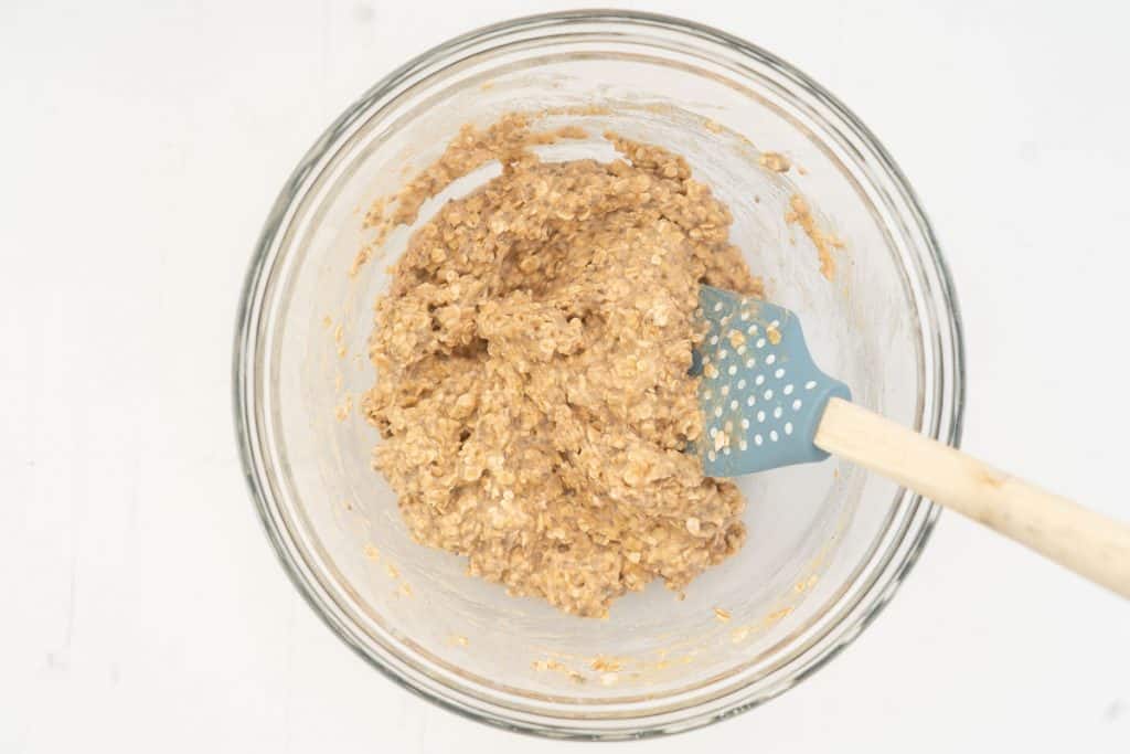 Applesauce oatmeal cookie dough in a glass mixing bowl.