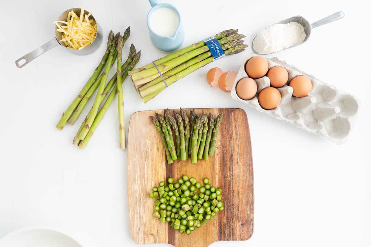 Asparagus on a wooden chopping boards, the tips have been removed and the based diced into 1cm pieces.