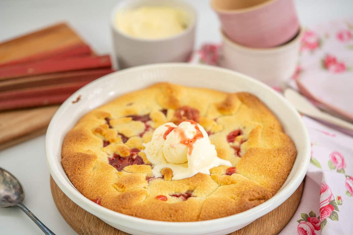 A rhubarb pie topped with vanilla ice cream.