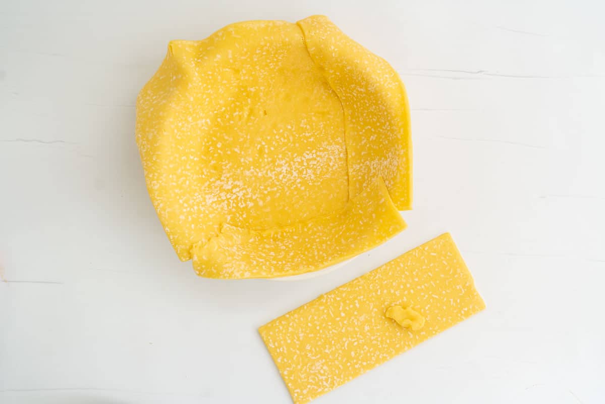 A pie dish lined with sweet short pastry.