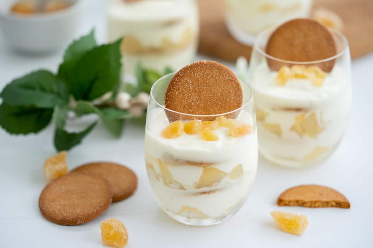 4 yogurt parfaits served in glasses on a table decorated with Christmas decorations.