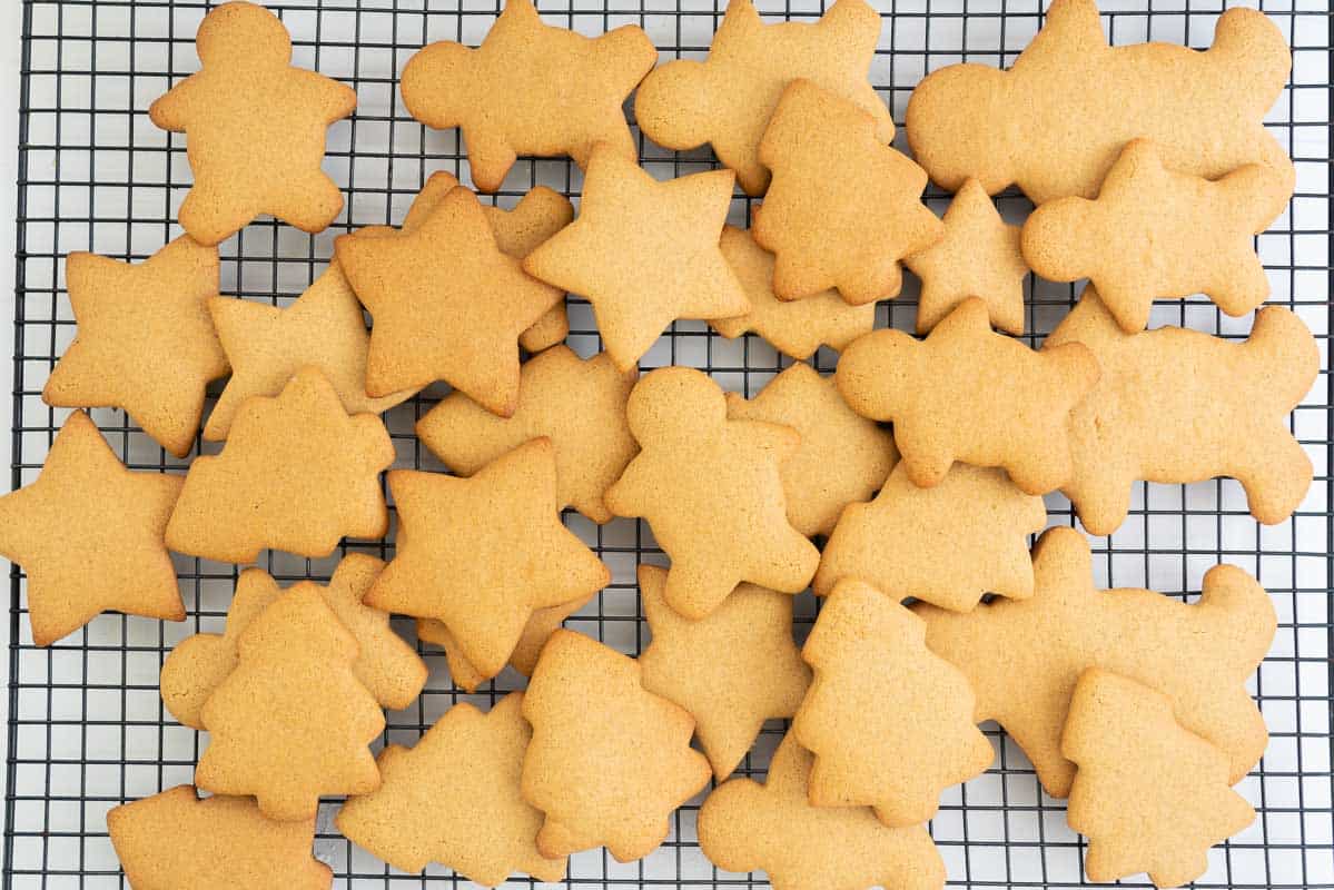 Gingerbread cookie shapes on a black cooling rack.