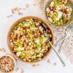 A large bowl of mixed bean salad on a white table top next to a small dish of dried beans.
