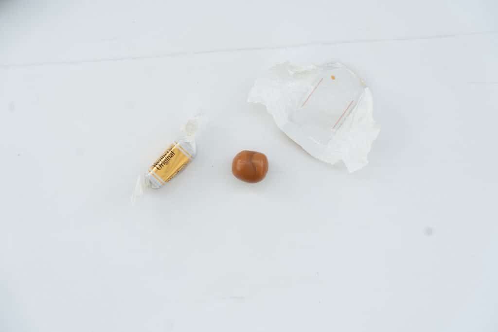 An unwrapped toffee rolled into a ball.