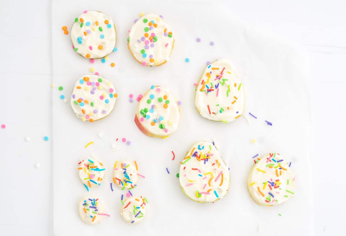 Slices of fruit, topped with yoghurt and rainbow sprinkles.