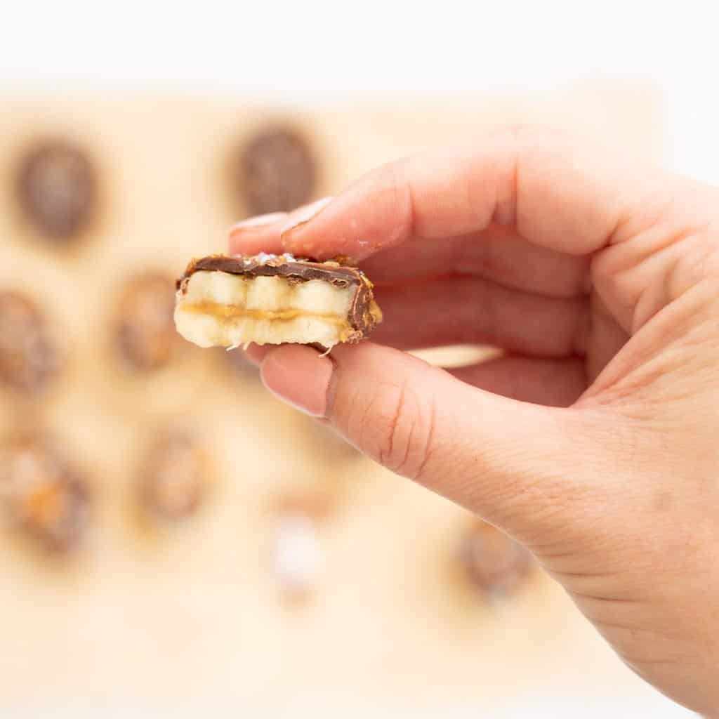 A half eaten,chocolate covered banana slices sandwiched together with peanut butter.