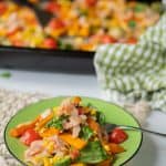 A serving of loaded sweet potato fries on a green plate ready to eat.