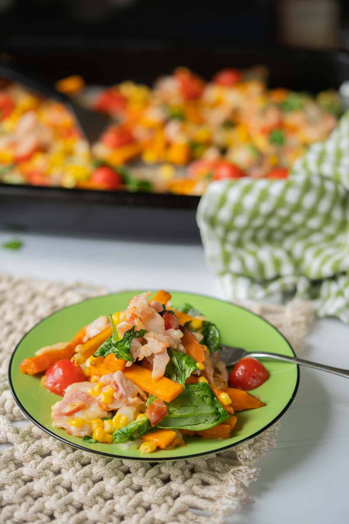A serving of loaded sweet potato fries on a green plate ready to eat.