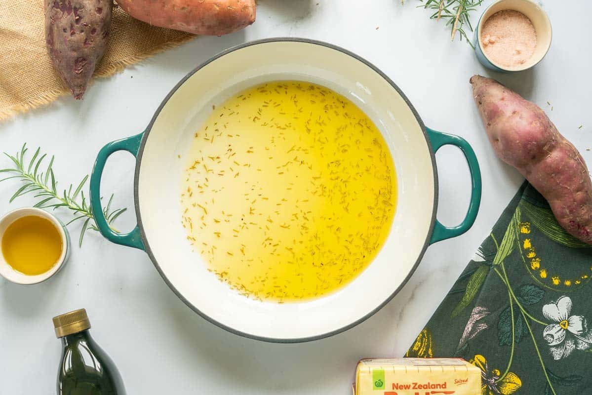 Melted butter and rosemary in the bottom of a large ceramic dish.