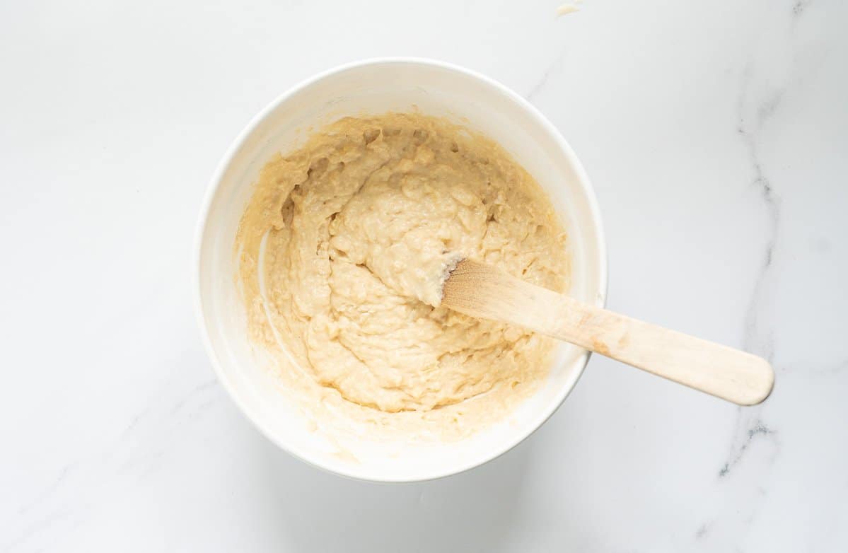 Pineapple muffin batter in a white ceramic mixing bowl.