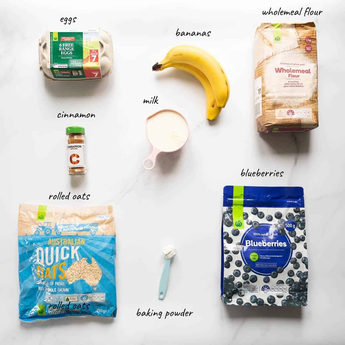 The ingredients to make banana blueberry oat waffles laid out on a bench top with text overlay.