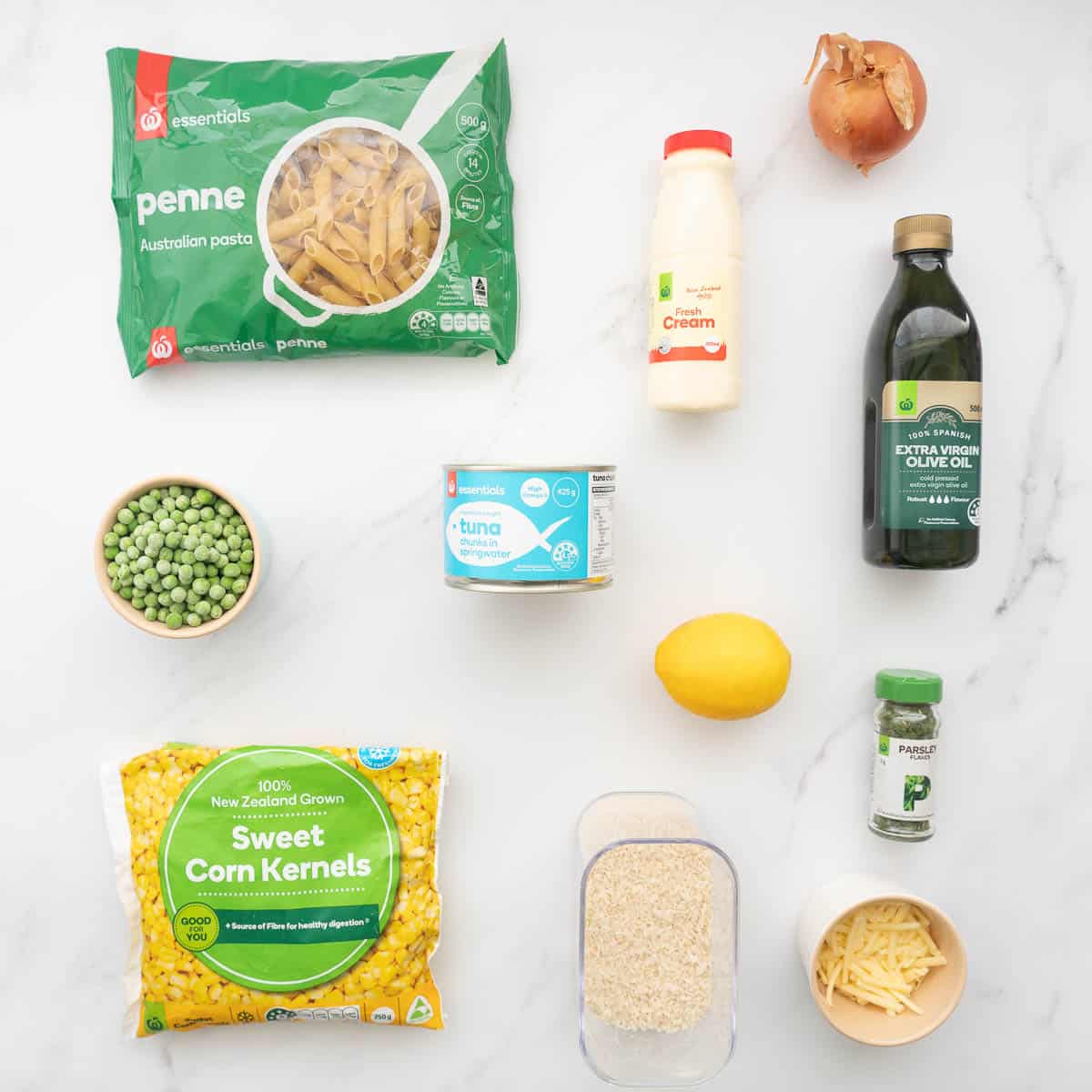 The ingredients to make tuna pasta bake laid out on a marble bench top.