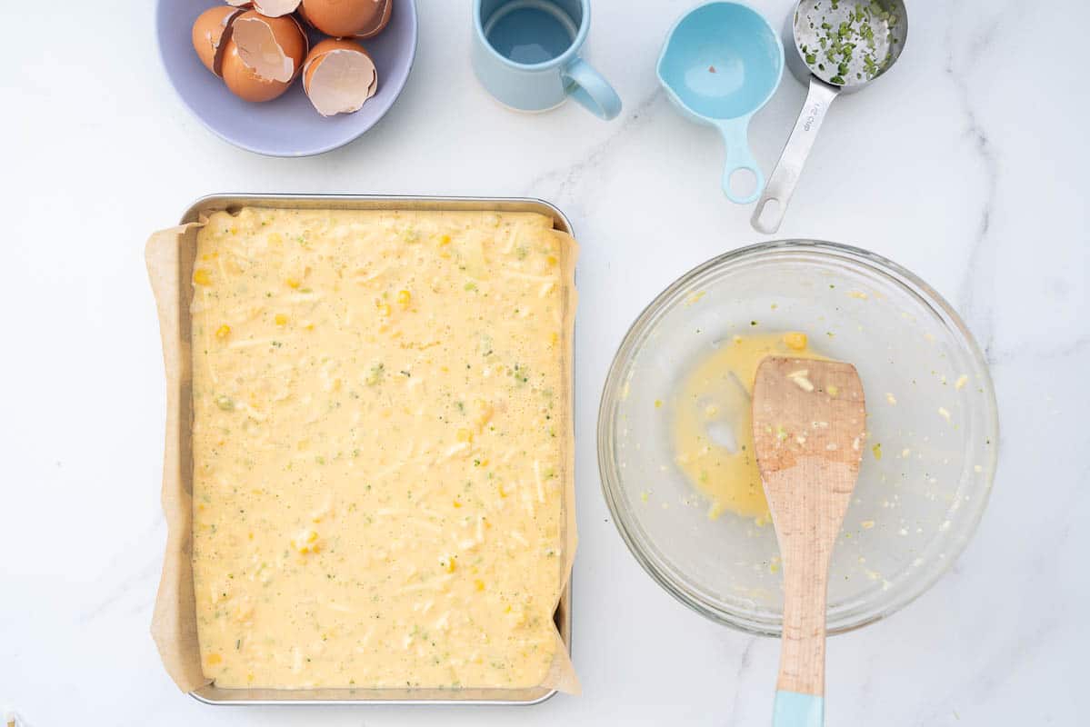 Vegetable slice batter in a lined slice tray ready to go into the oven.