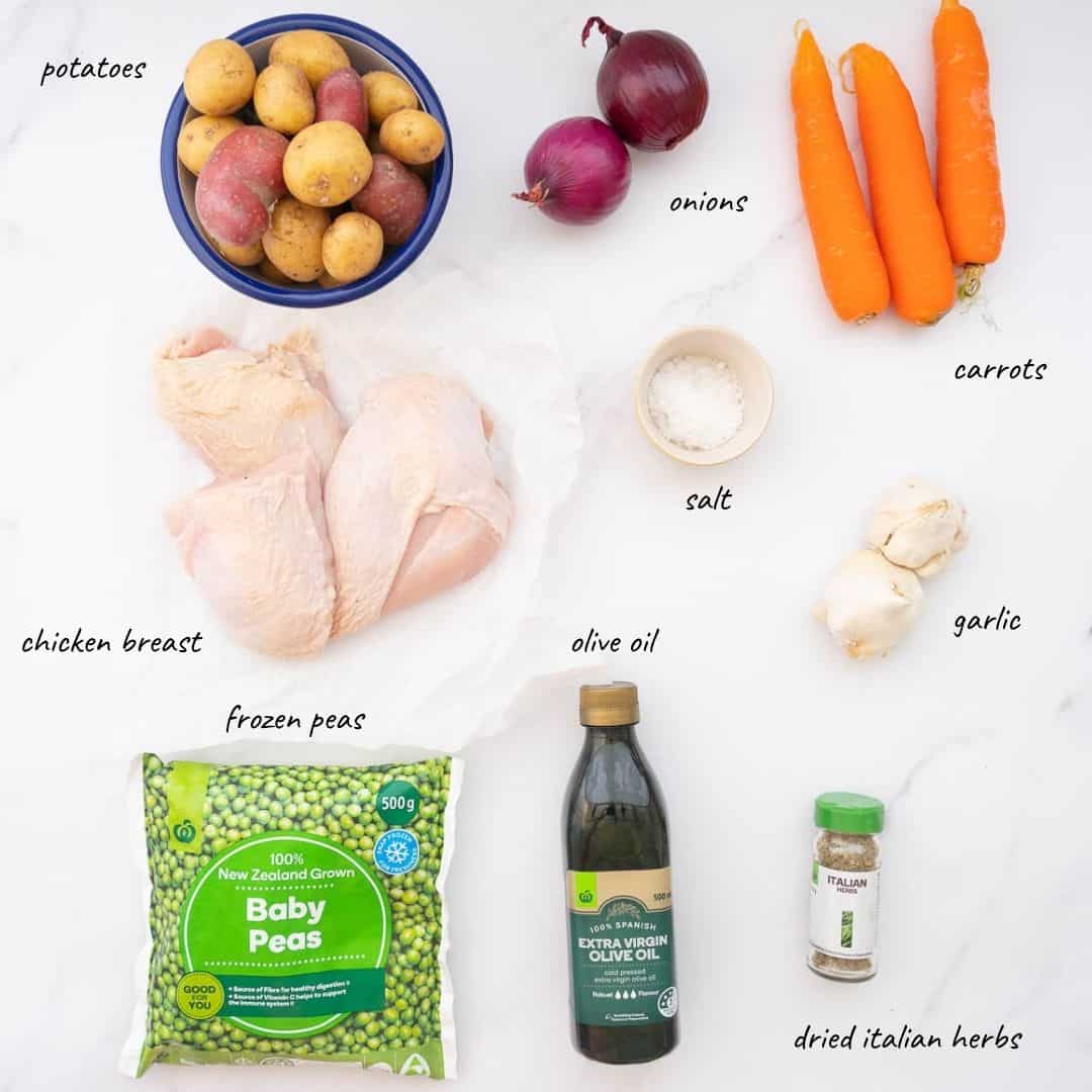 The ingredients to make a roast chicken tray bake laid out on a bench top with text overlay.