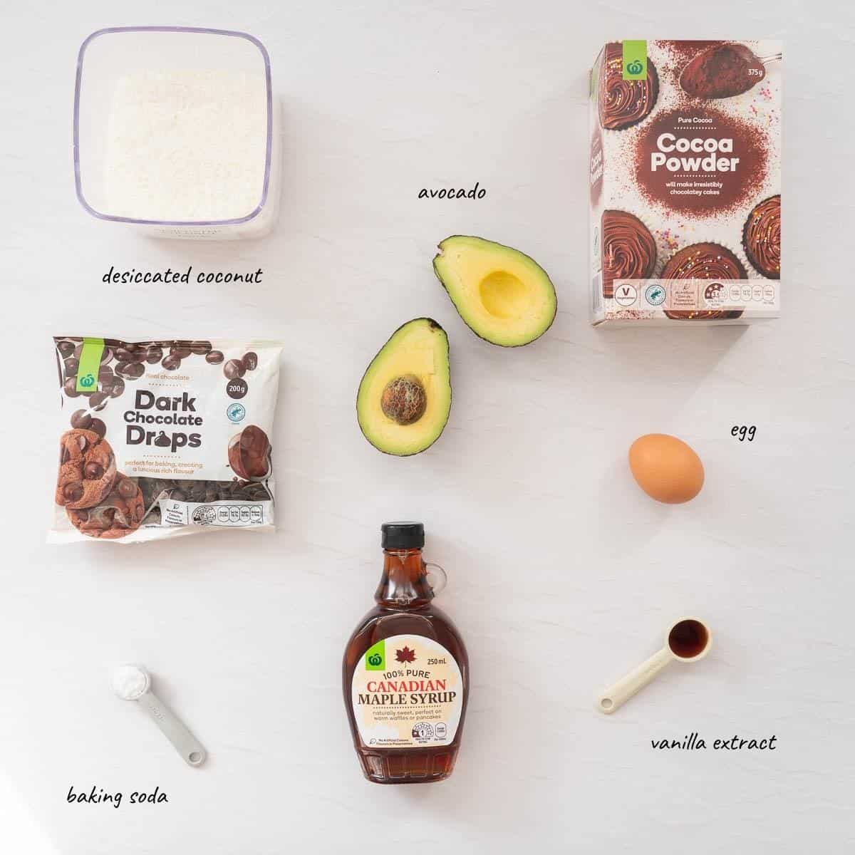 The ingredients to make chocolate avocado cookies laid out on a bench top with text overlay.