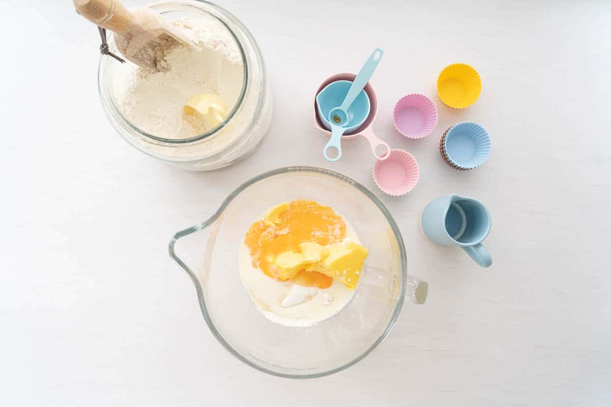 A glass mixing bow from an electric beater filled with baking ingredients.