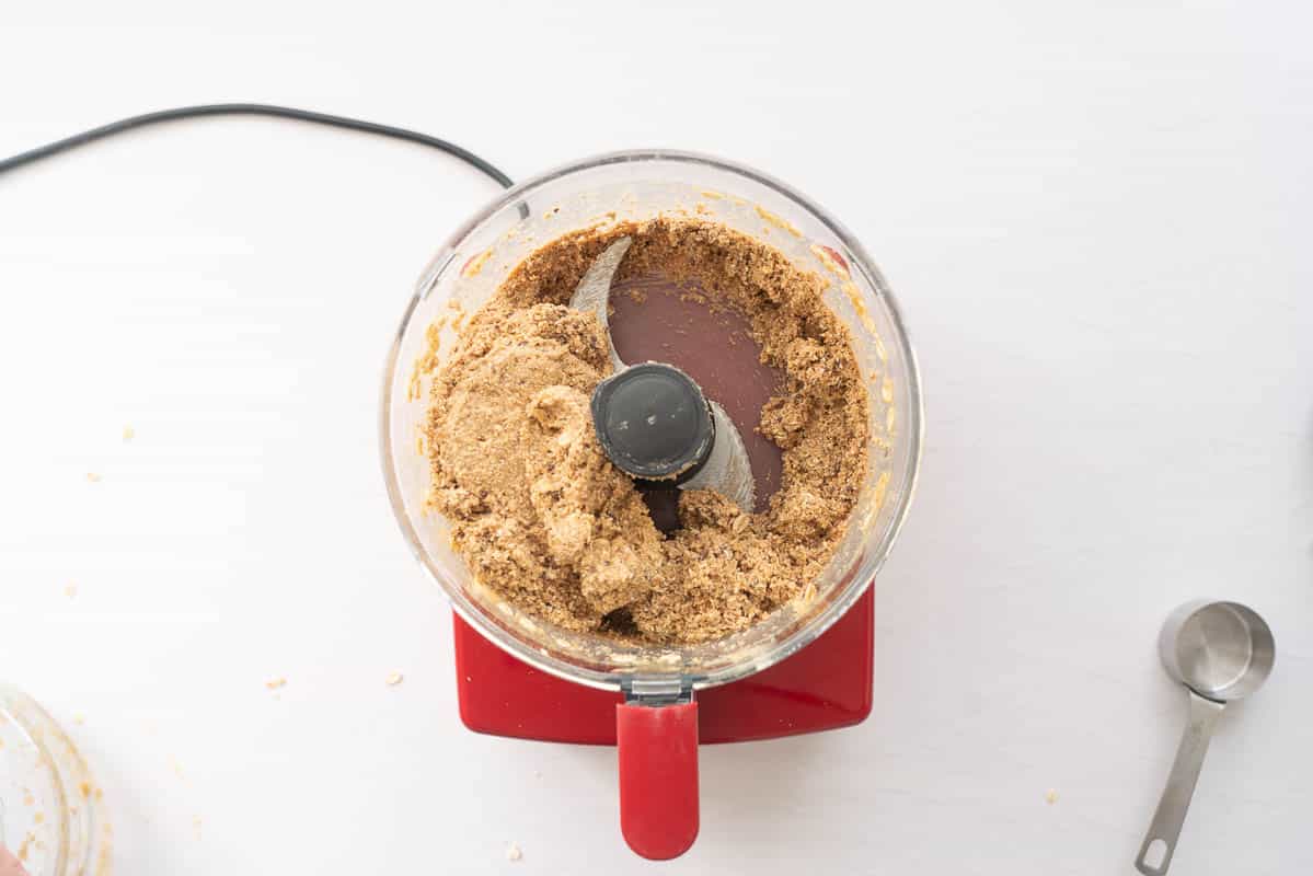 No-bake banana bread batter in a large ball in a food processor.