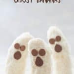 3 banana halves standing upright on a terrazzo platter decorated to look like ghosts with text overlay.