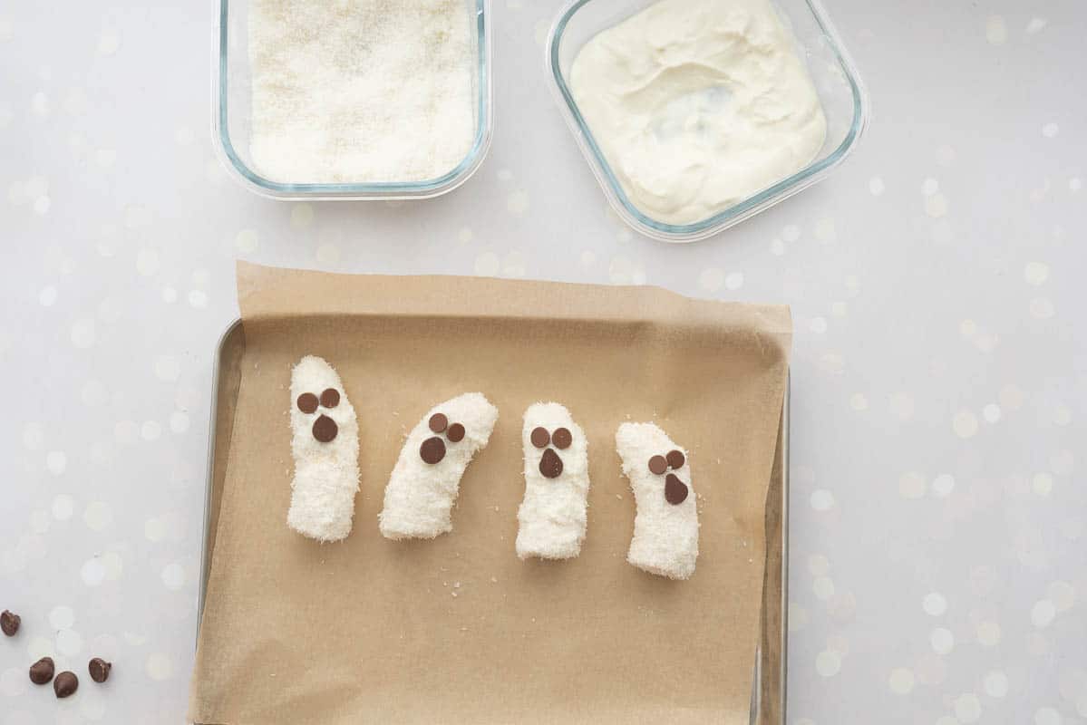 4 banana halves decorated to look like banana ghosts