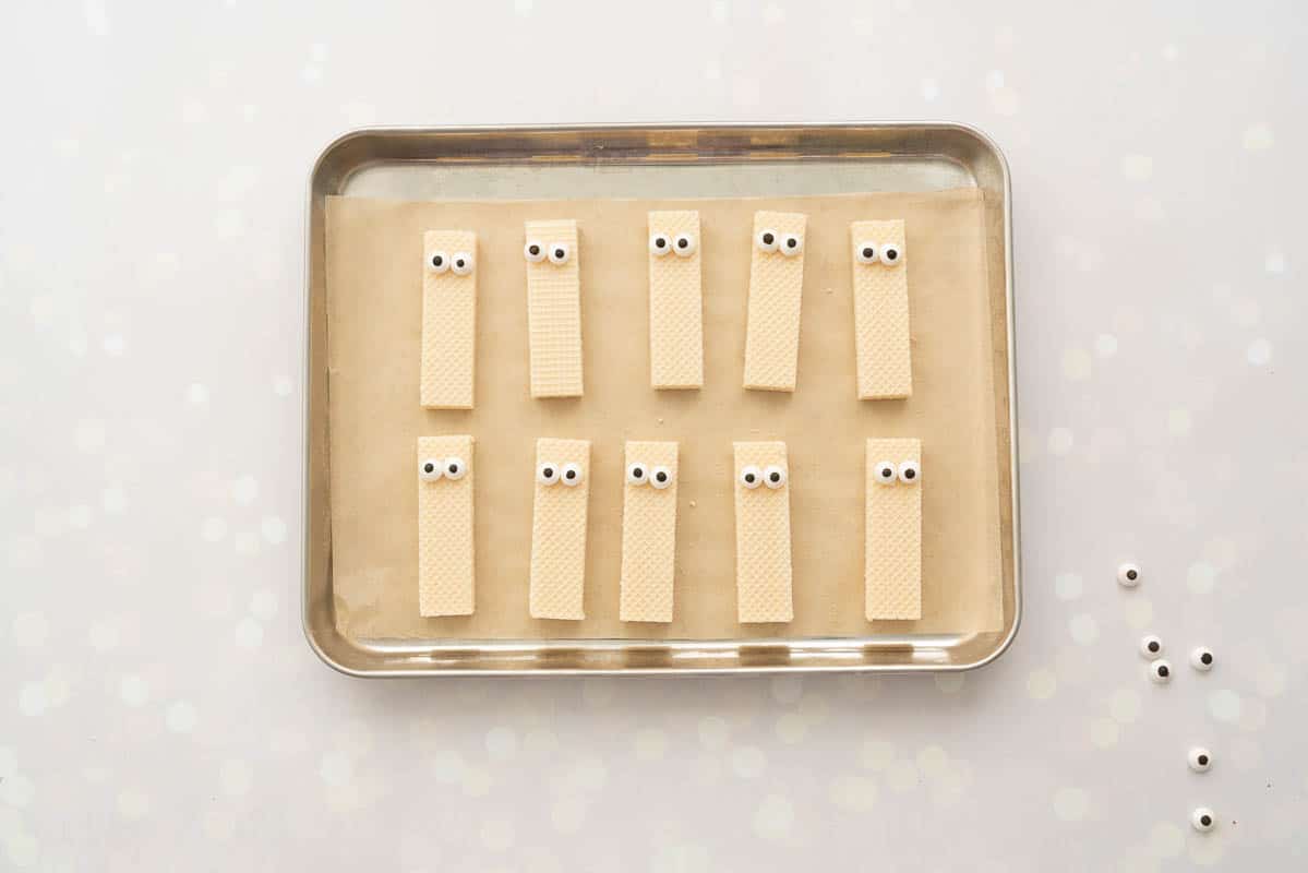 Vanilla wafer biscuits with candy eyes attached to them.