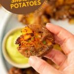 A golden brown smashed potato with skin on being held above a plate of smashed potatoes with text overlay