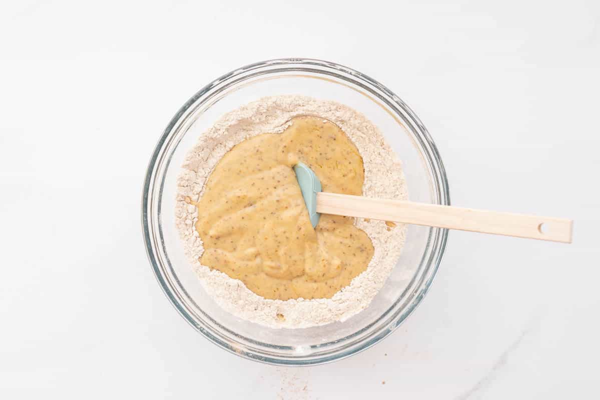 The wet ingredients and dry ingredients for healthy christmas cookies dough in a bowl ready to be mixed.