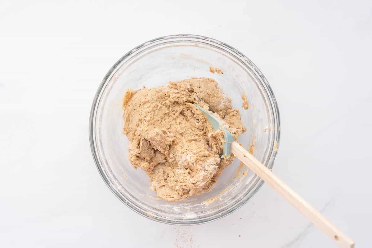 A ball of cookie dough in a glass mixing bowl.
