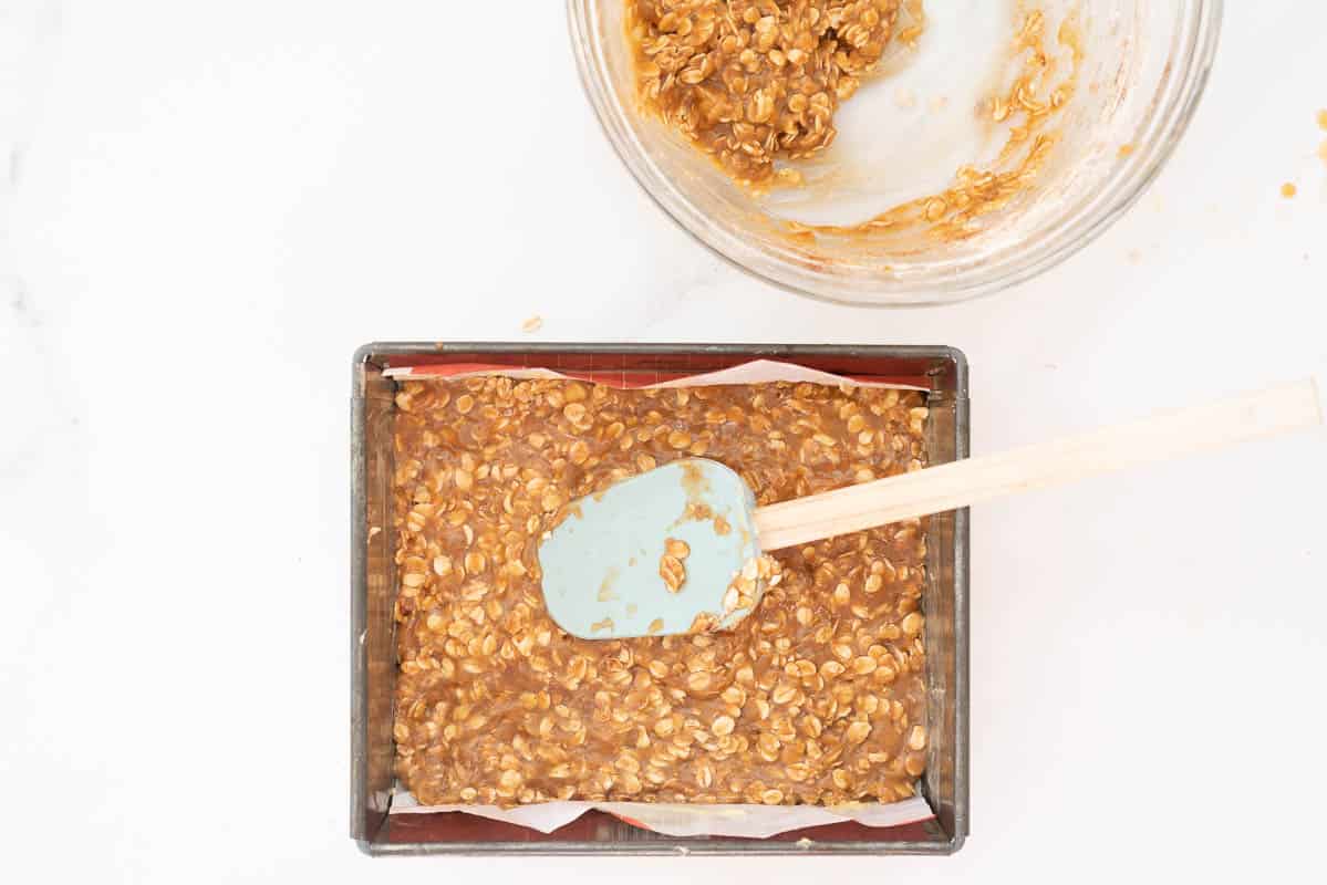 An oat based slice mixture pressed into the bottom of a lined slice tin.