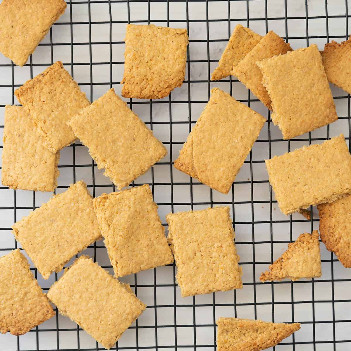 Golden brown rectangular oat crackers on a cooling rack.