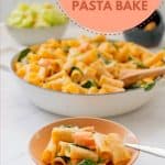 A light pink ceramic bowl cooked pasta in a cremy sauce with salmon, spinach leaves and peas also visible with text overlay.