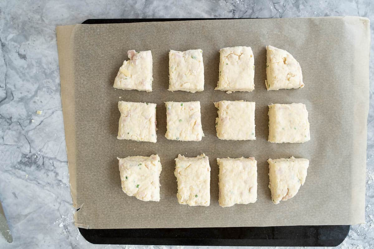 Twelve scones on a lined baking tray ready to go into the oven.