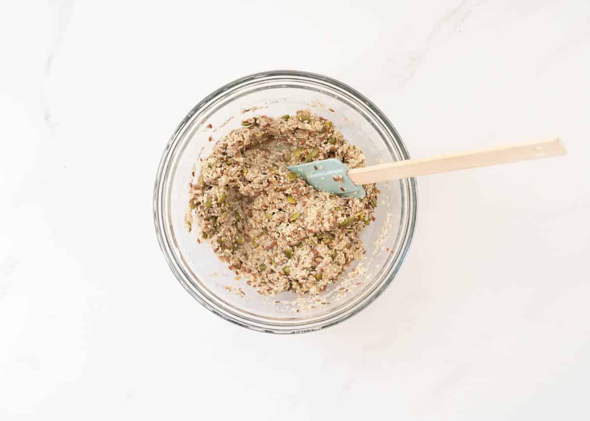 Seeded cracker mix, bound together in a mixing bowl.