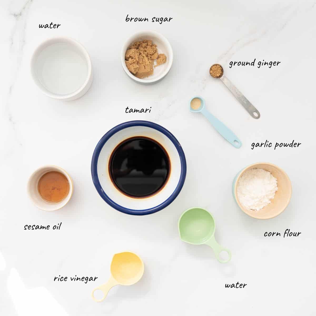 The ingredients to make gluten-free teriyaki sauce laid out on a bench with text overlay.