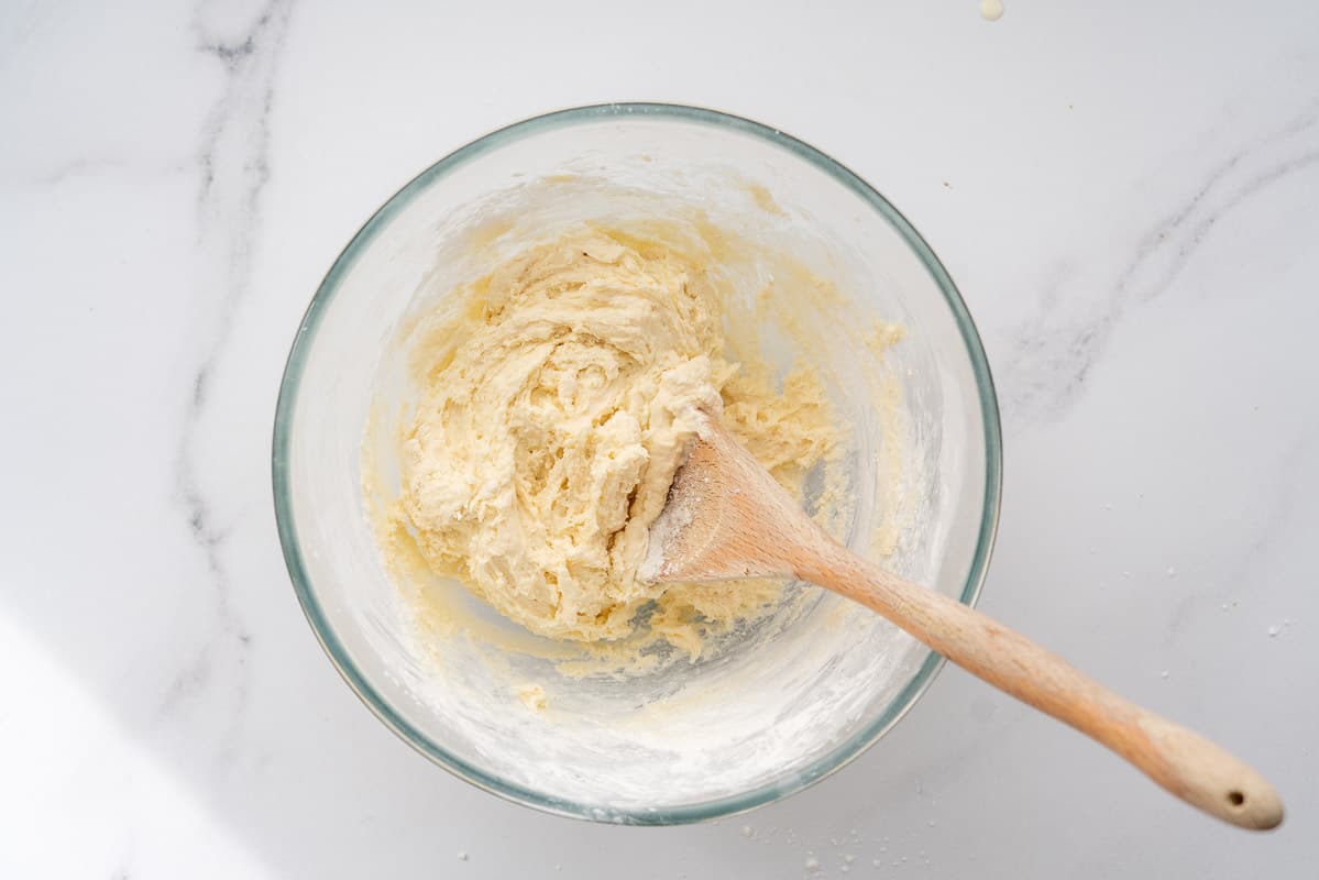 A glass mixing bowl of sticky bread batter.