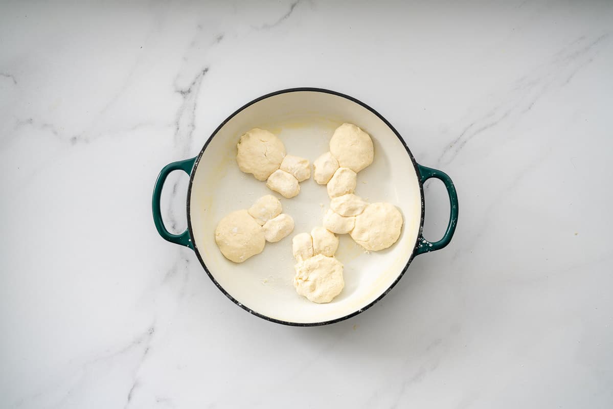 5 gluten free bunny buns in an oven proof dish ready to go in the oven.