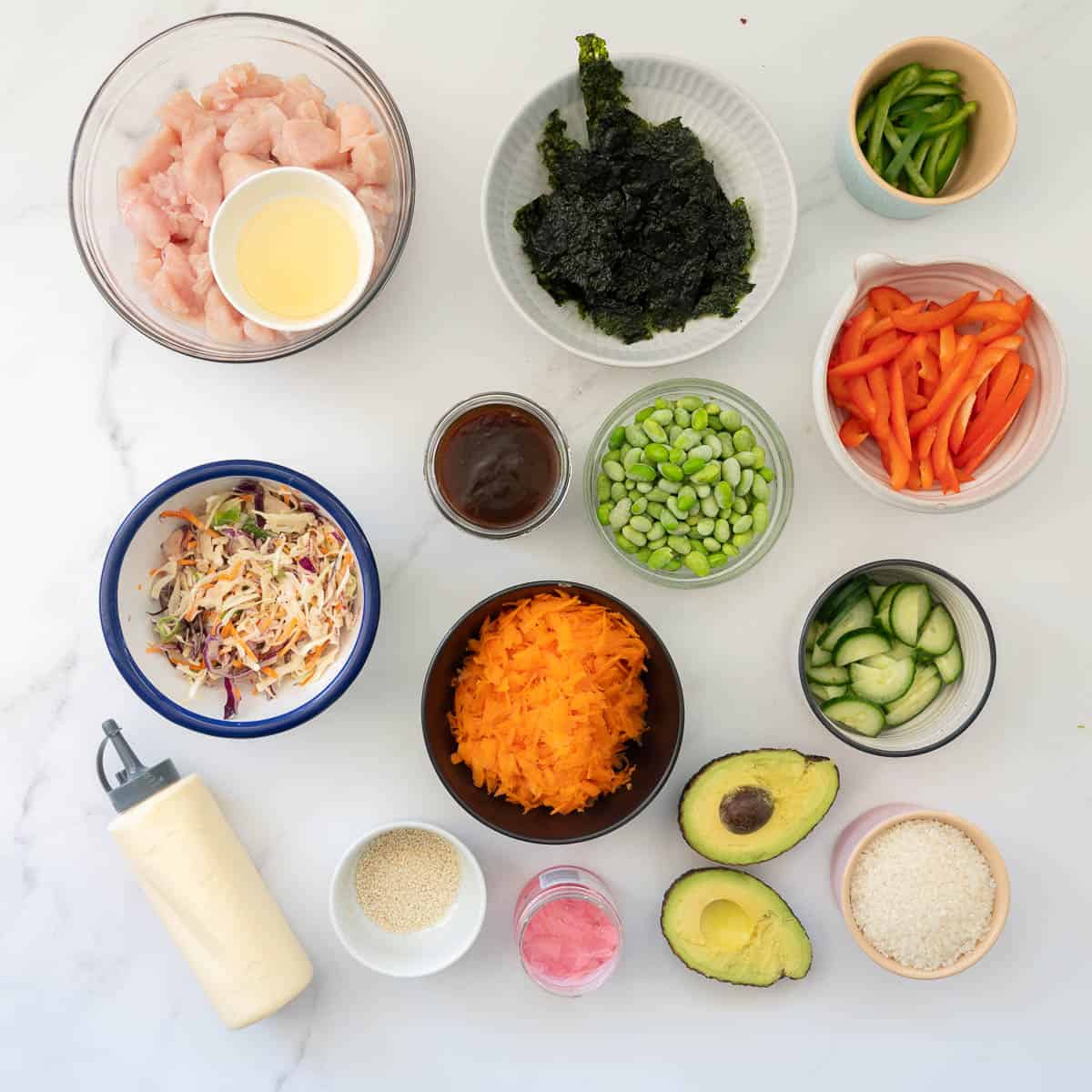 Salad ingredients and condiments ready to make sushi chicken bowls.