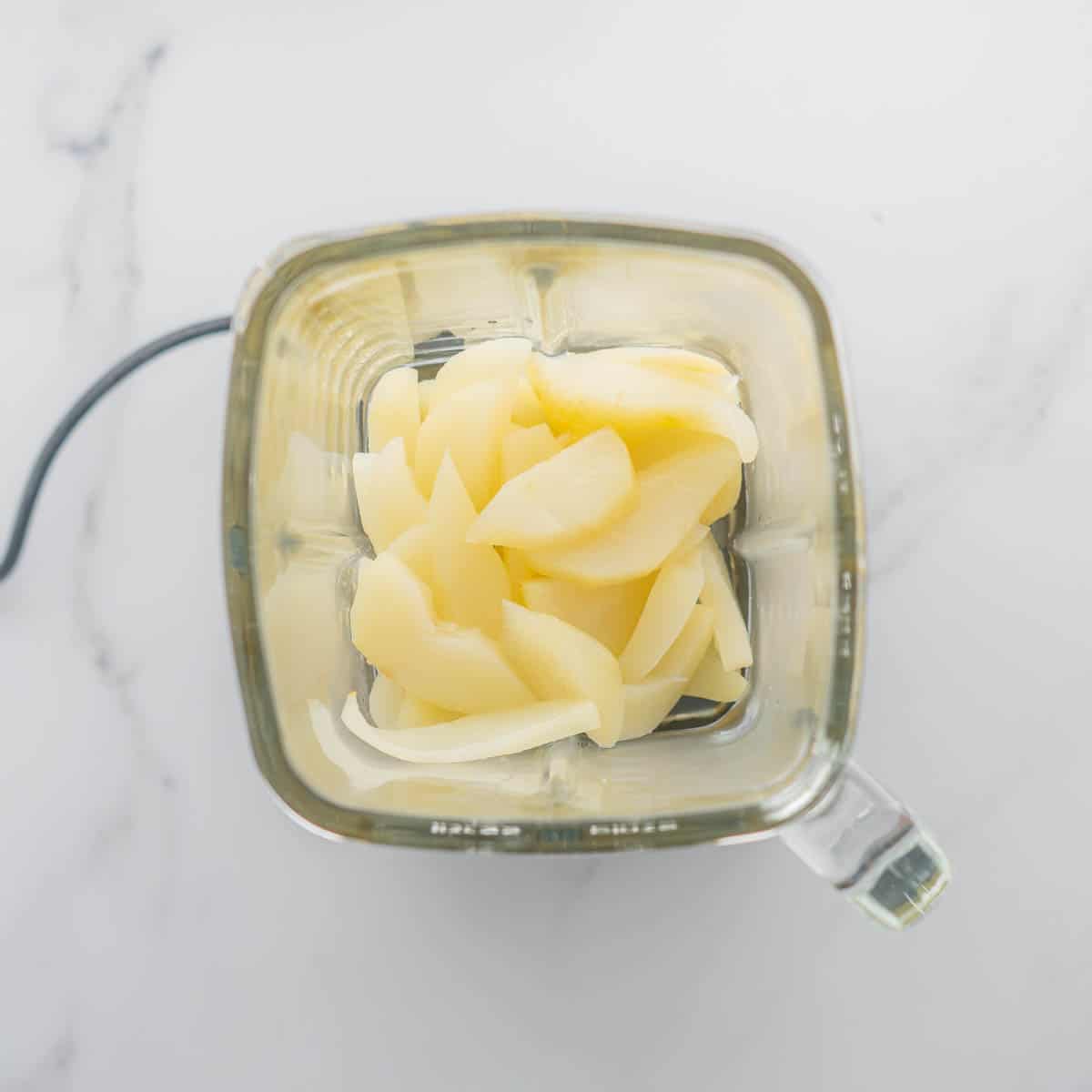 Steamed pear slices in a glass blender jug.