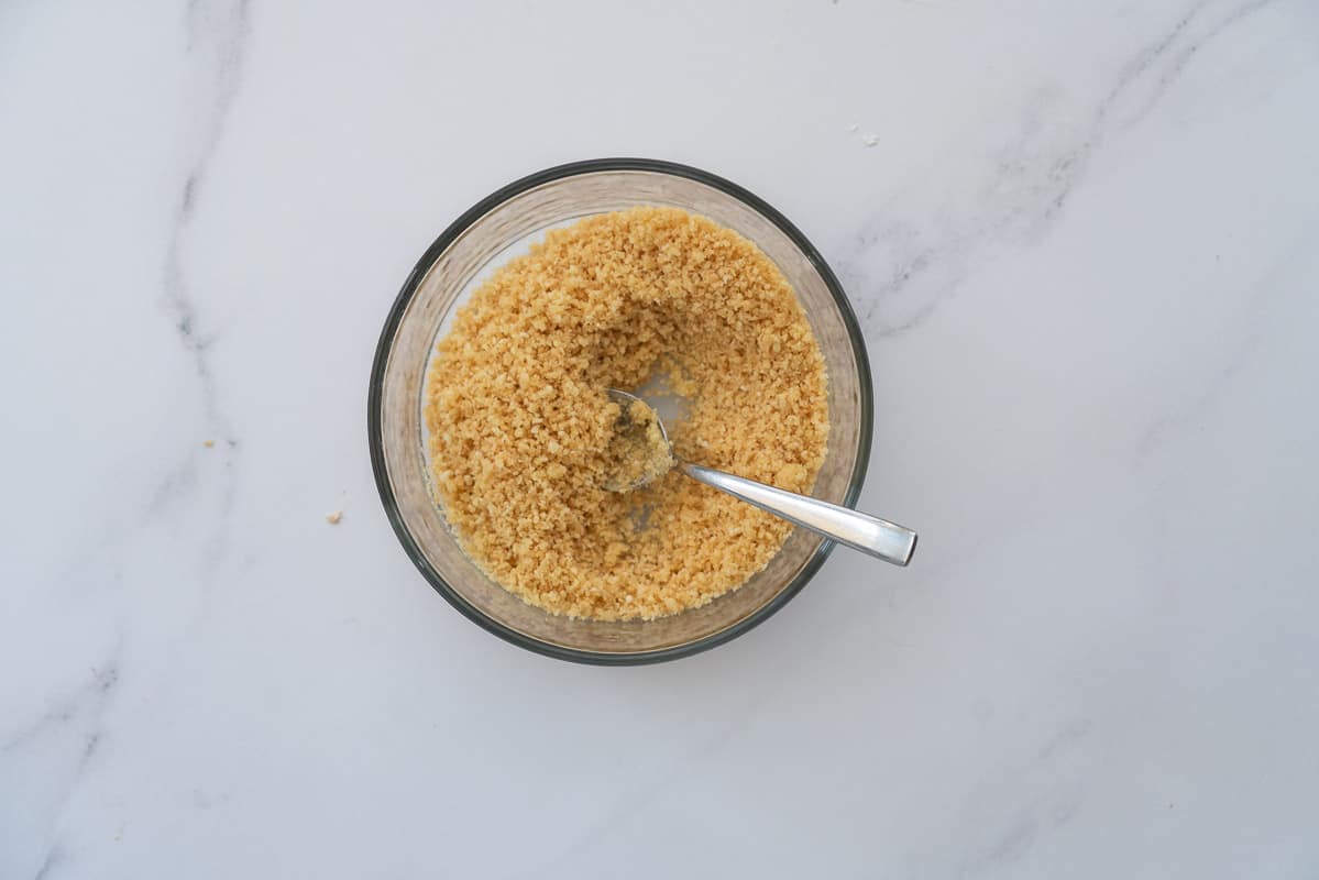 Oiled bread crumbs in a small glass mixing bowl.