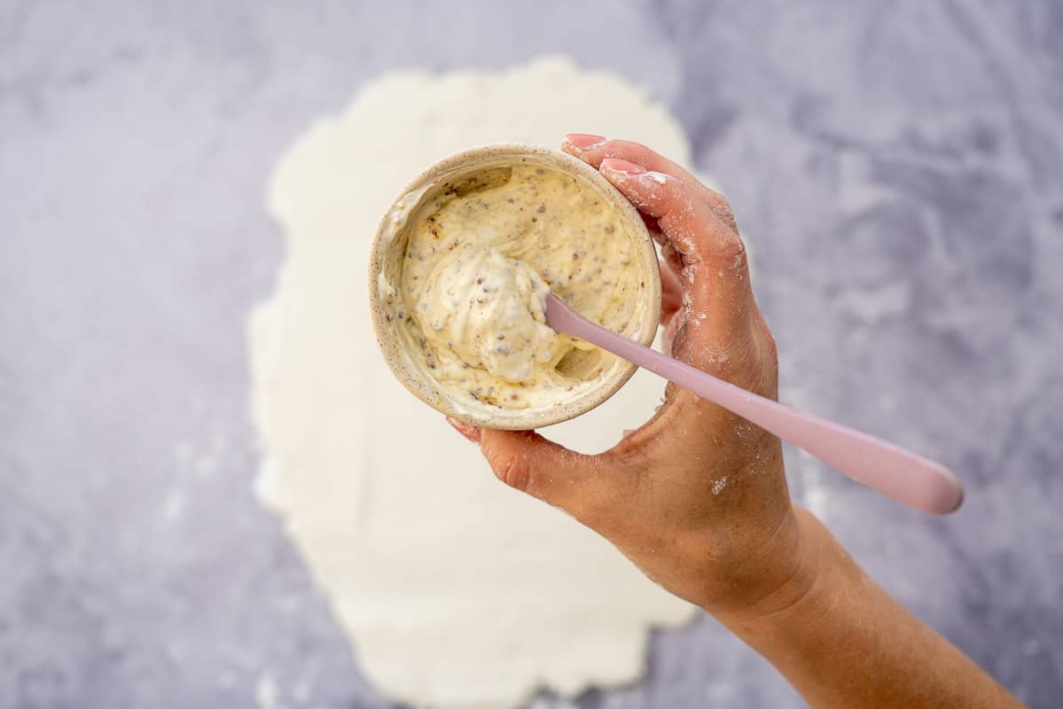 A small ceramic bowl filled with sour cream and mustard.