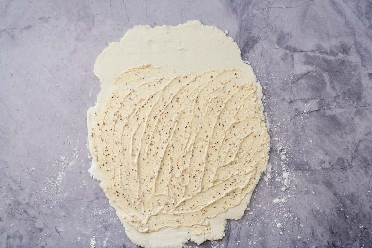 Sour cream and mustard spread over a rectangle pizza base.