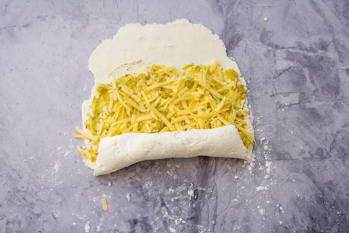 Pizza dough log being rolled up.