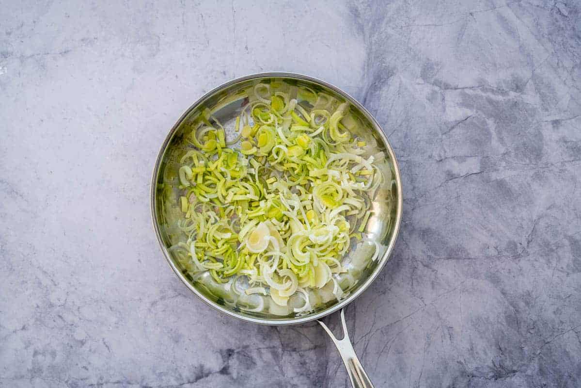 Sliced leek in a stainless steel pan