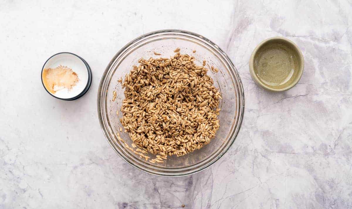 A mixing bowl with sunflower seeds mixed with the honey mixture