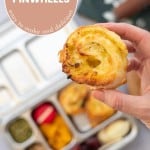 A scroll being held above a packed stainless steel lunchbox with text overlay for pinterest