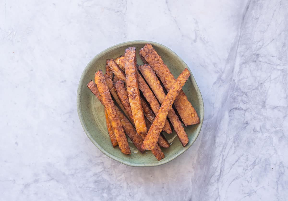 Cooked tofu in a bowl on bench top.