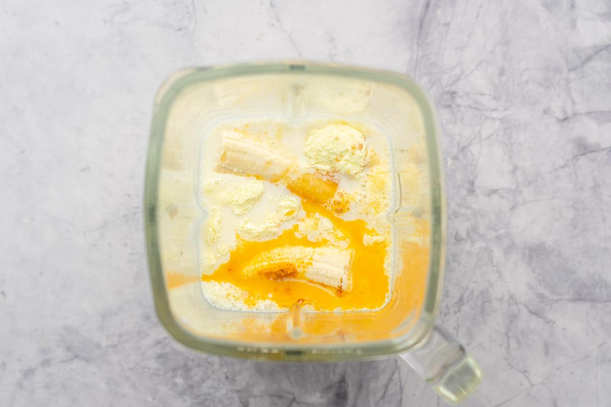 Banana milk and turmeric powder in a blender jug.