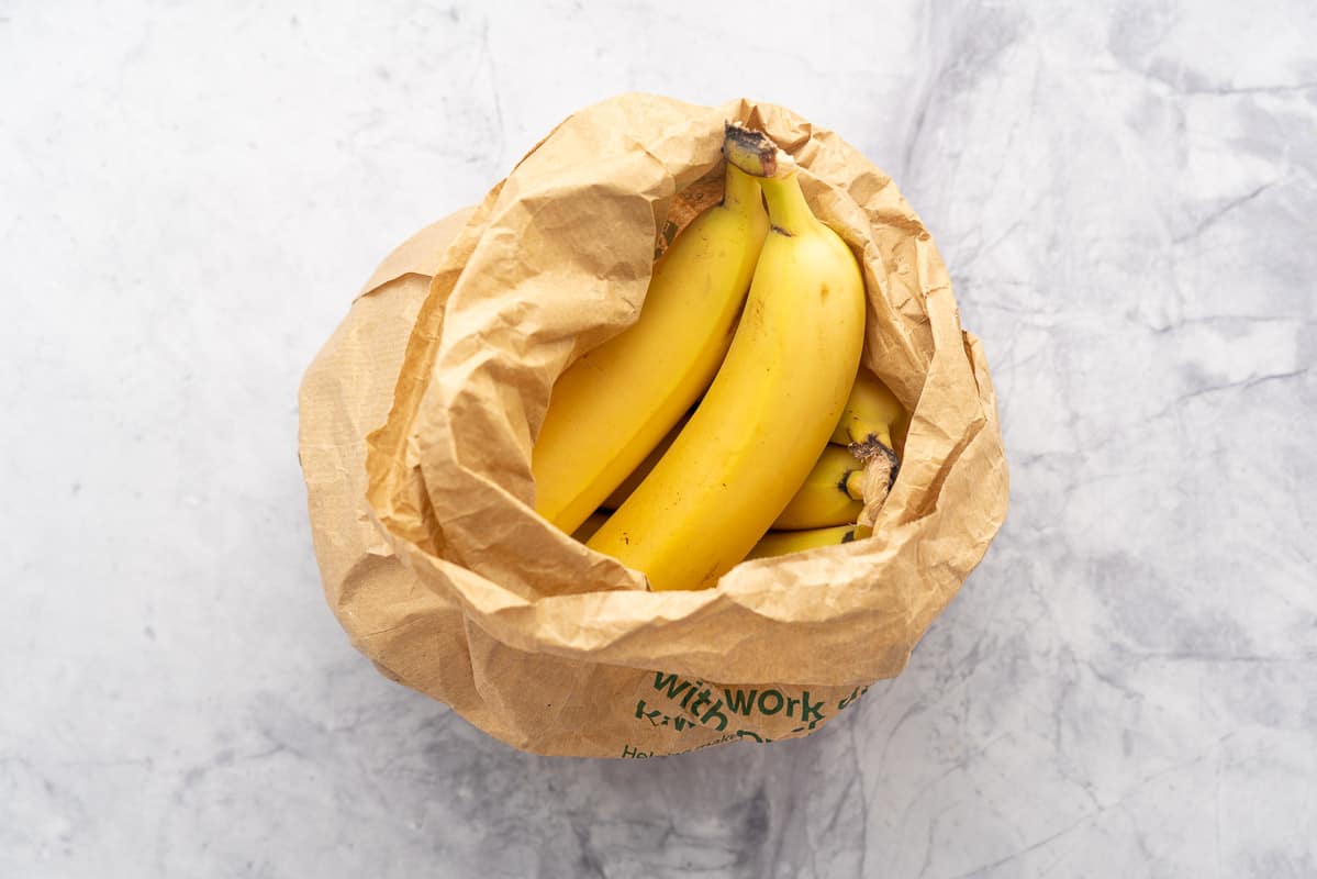 Bananas in a brown paper bag.