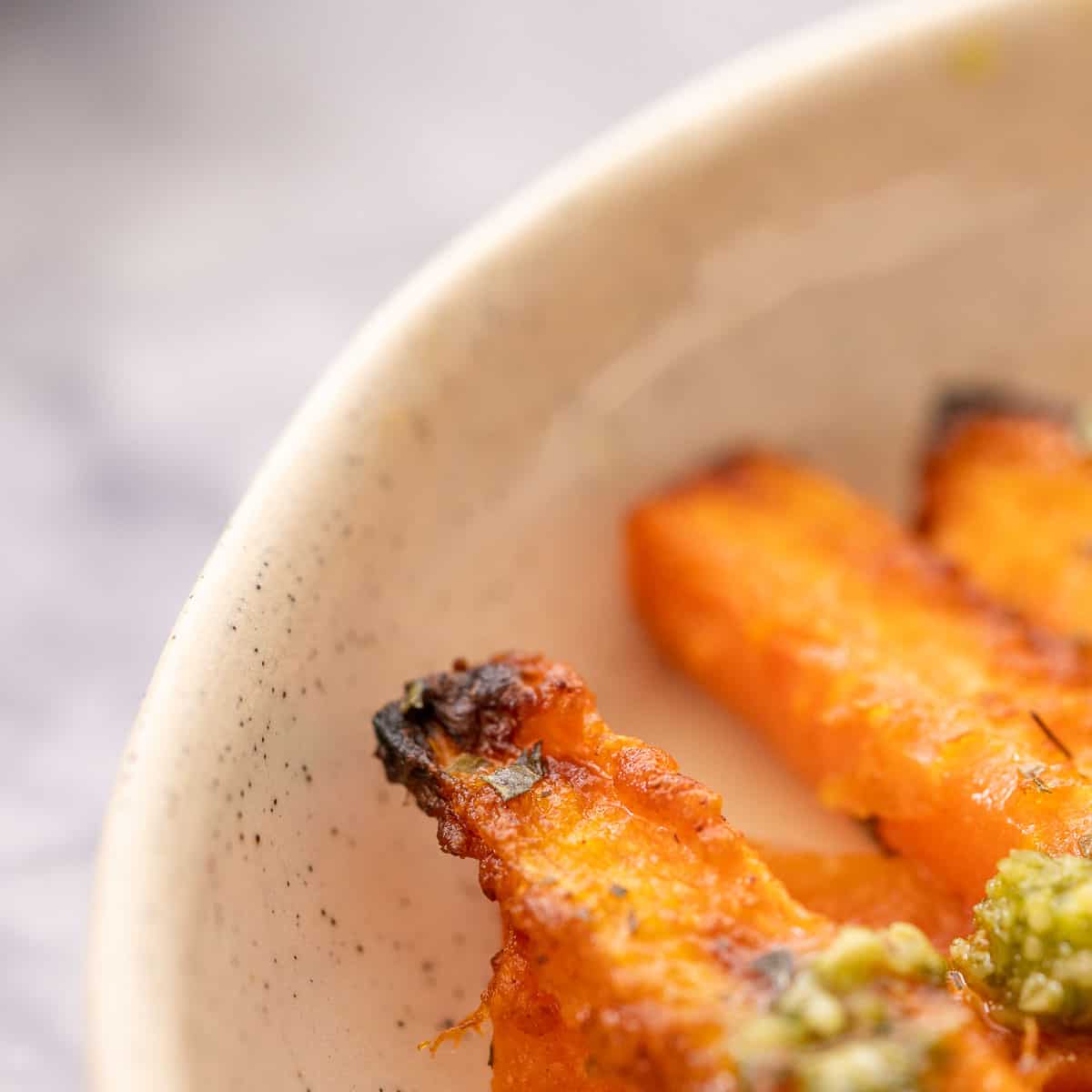 A closeup of the end of a carrot fry showing the blackened end.