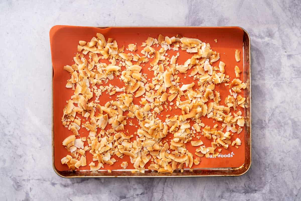 Toasted coconut spread out on a lined baking dish