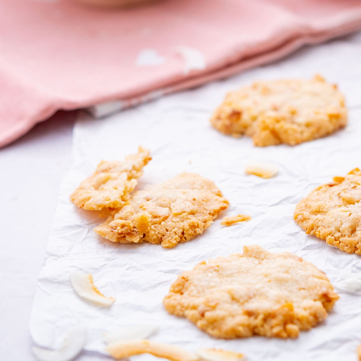 A cookie broken in half on a sheet of crinkled baking paper